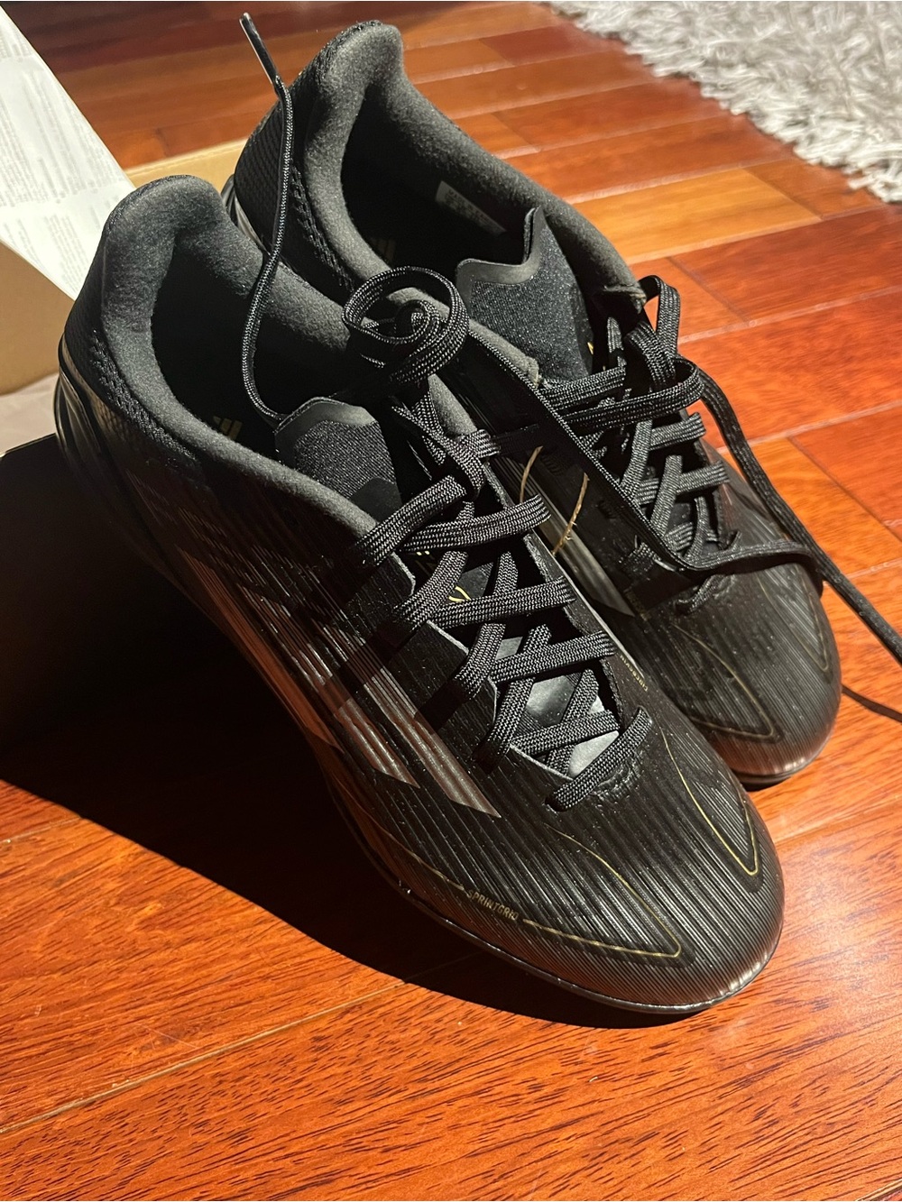 adidas Men's Black Athletic Soccer Style Cleats with Subtle Gold Accents